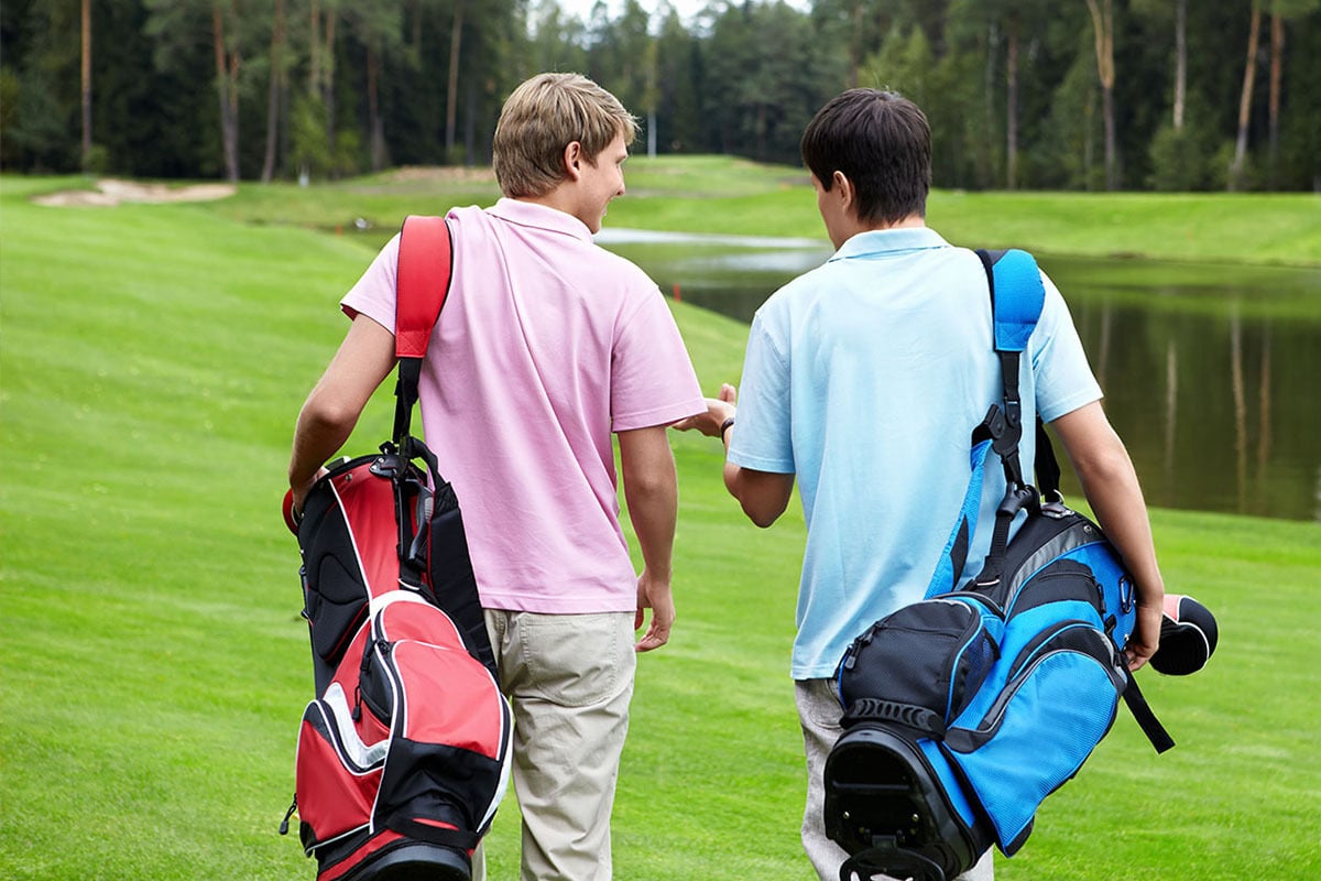 two men on a putting green with their backs facing the camera 