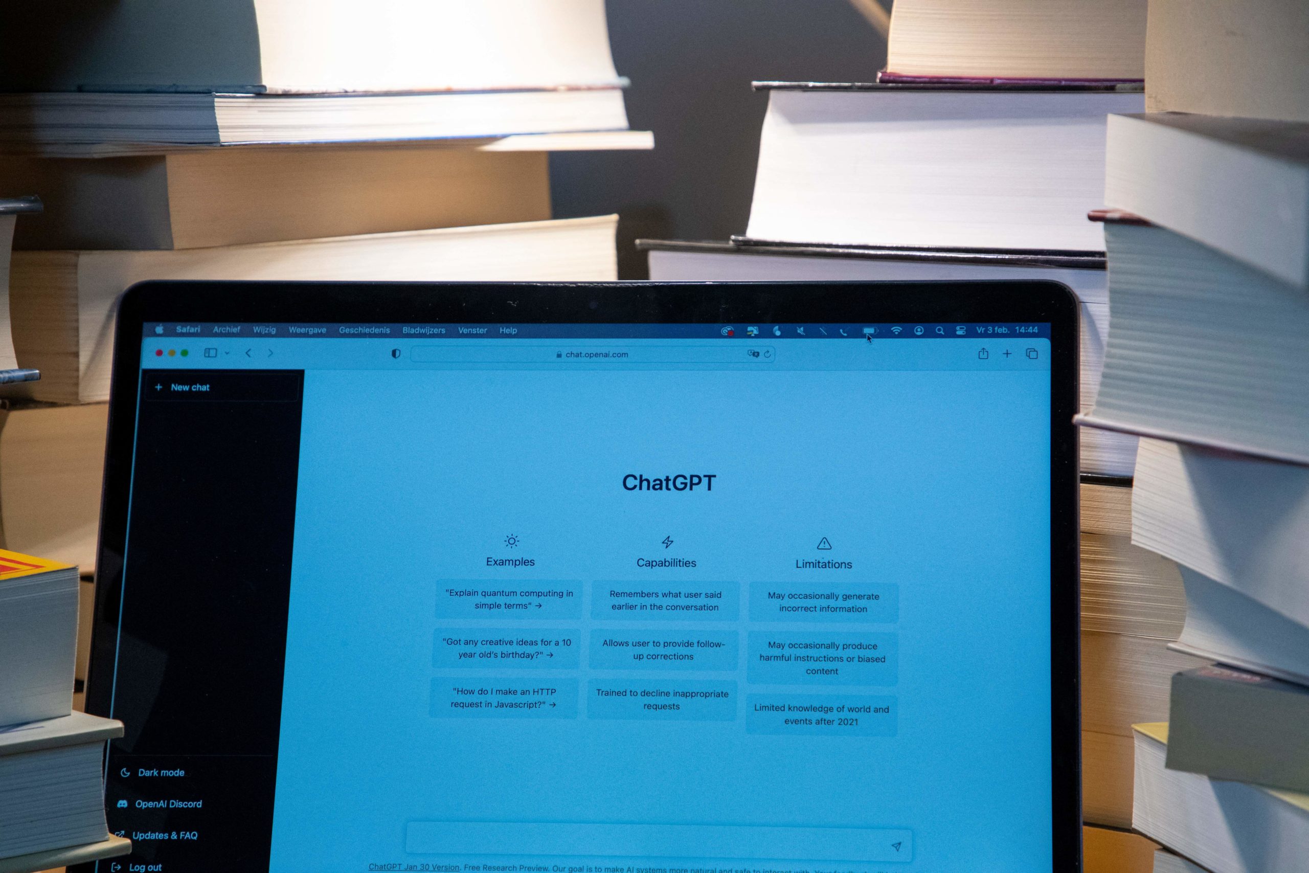 chatgpt displayed on a laptop surrounded by books