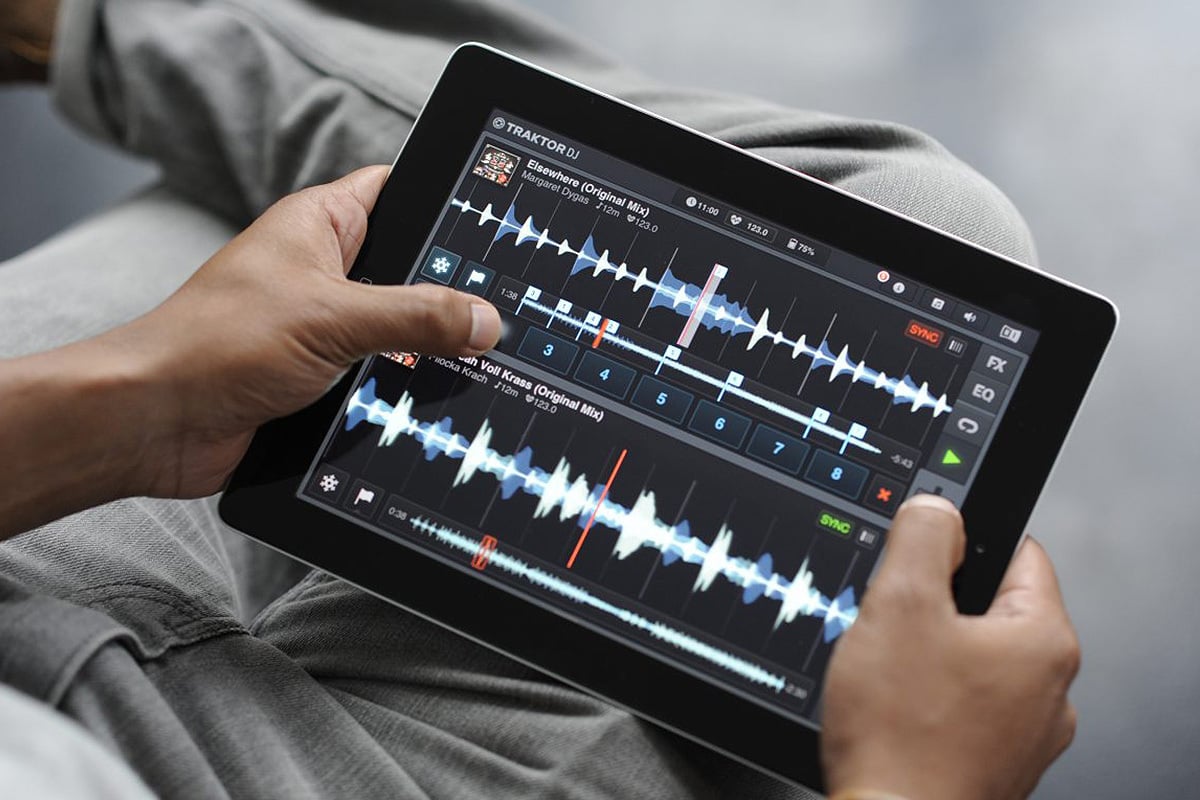 person is holding ipad with a music editing software on screen