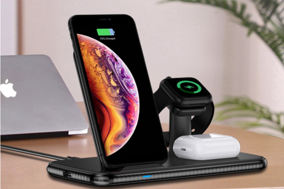 wireless charging hub charging up an iphone, a smartwatch, and airpods.