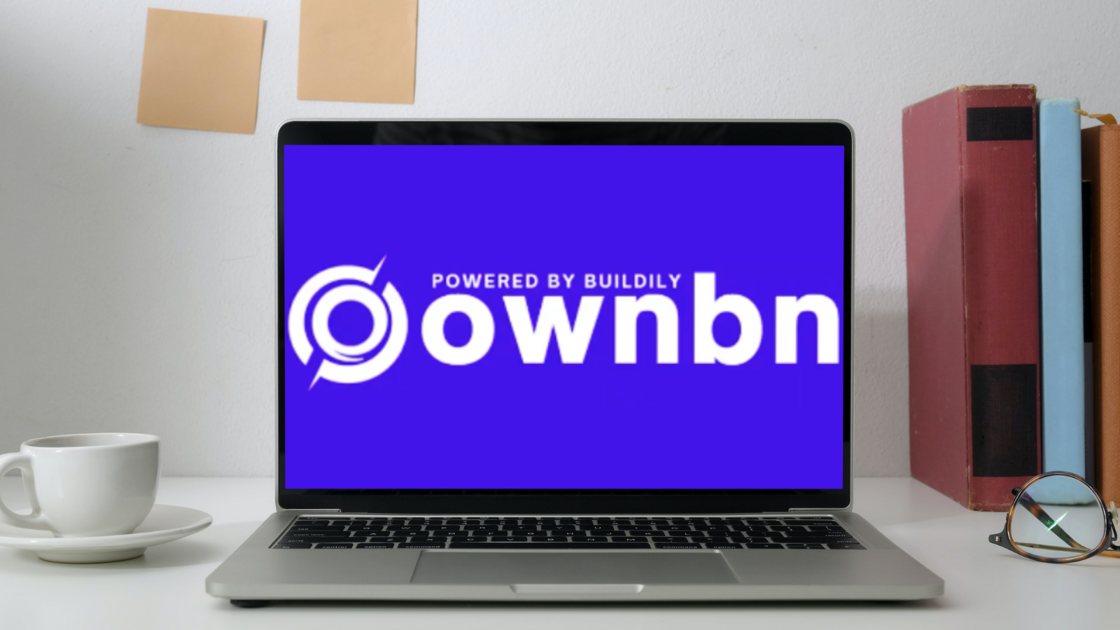 laptop on desk with OWNBN logo on screen