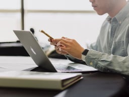 Phone in hands in front of laptop