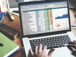 person using microsoft excel on laptop