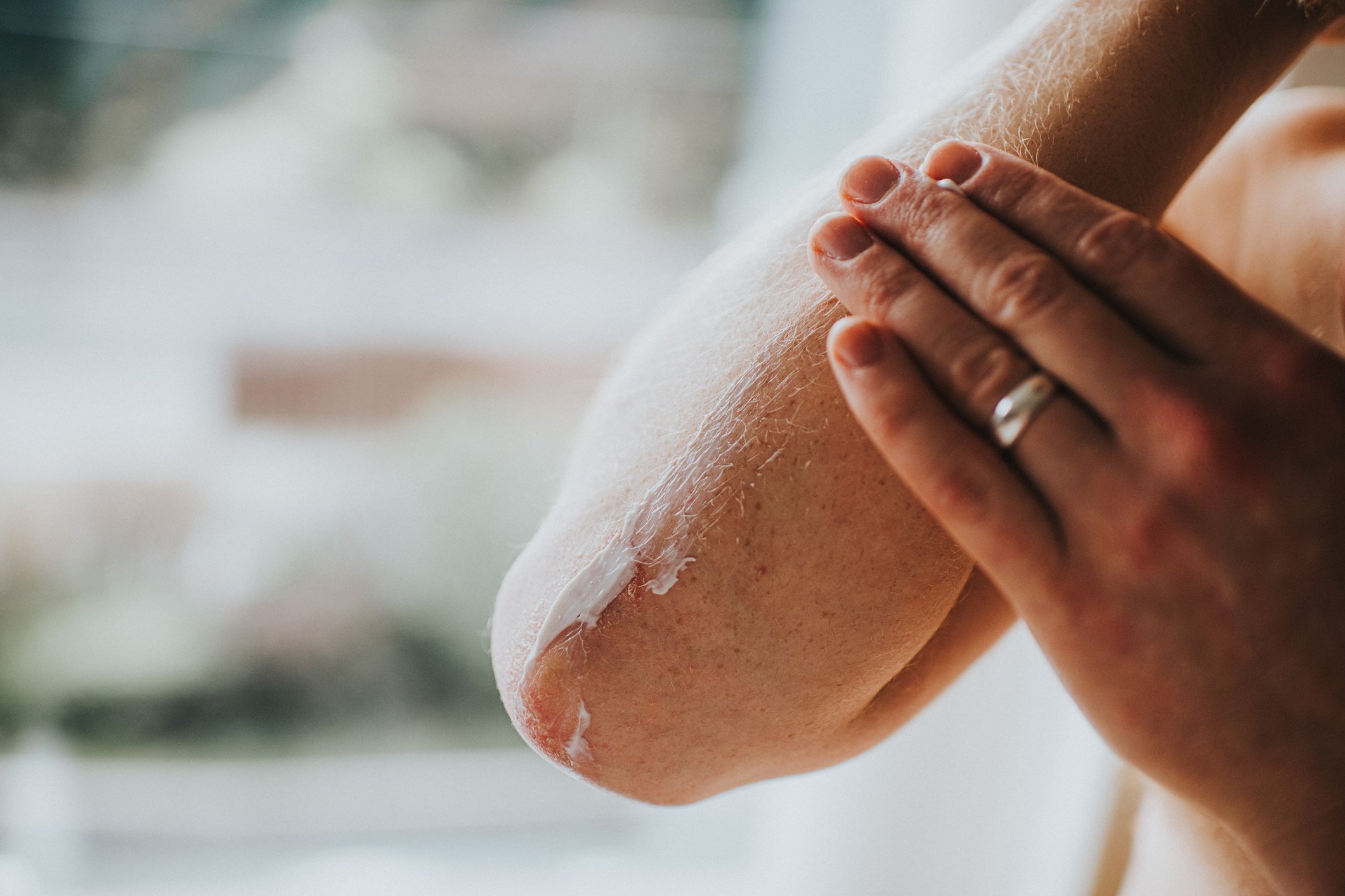 Close up of person hand applying lotion to their forearm