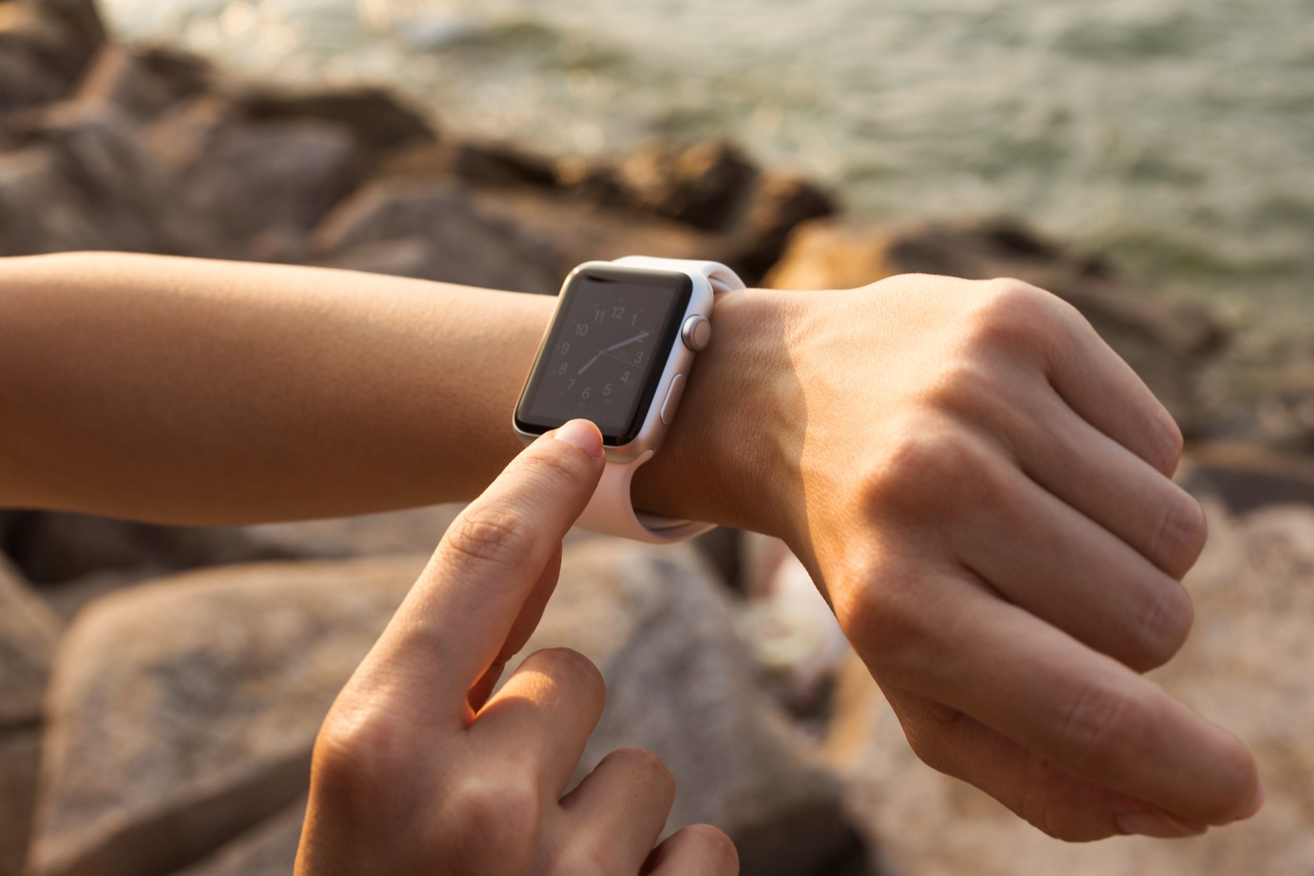 A person wearing 42mm stainless steel Apple Watch with white sports band.