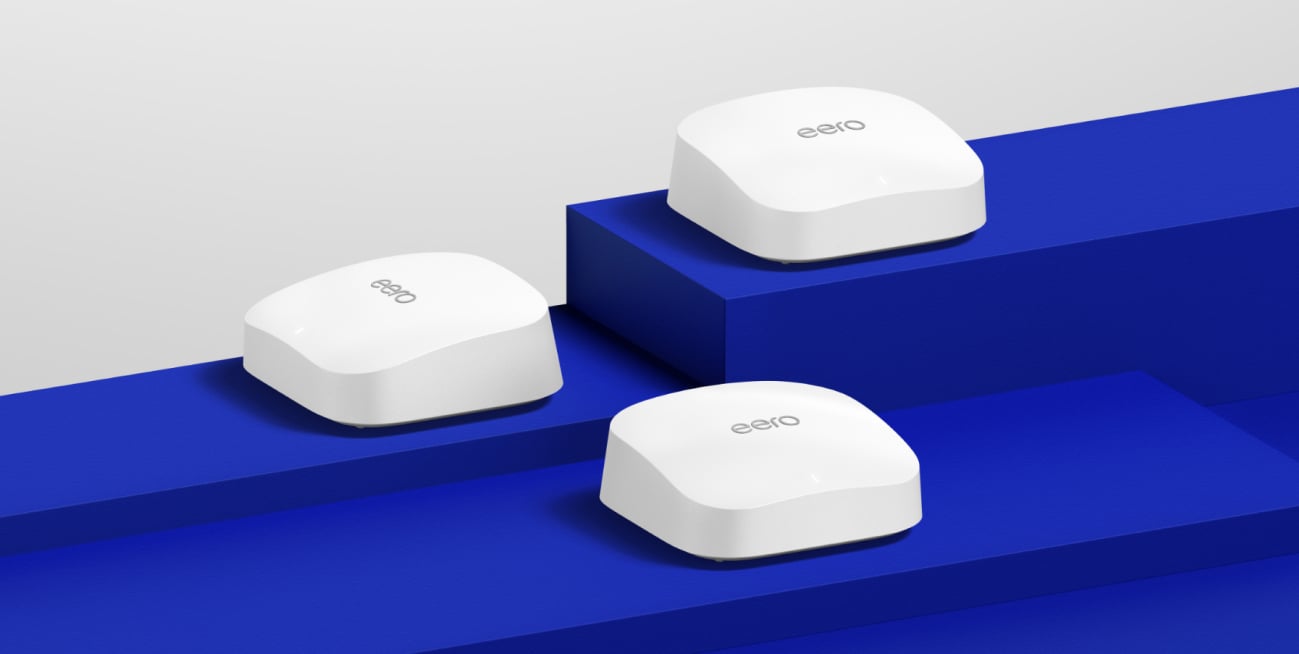 Three Amazon eero routers on a blue pedestal