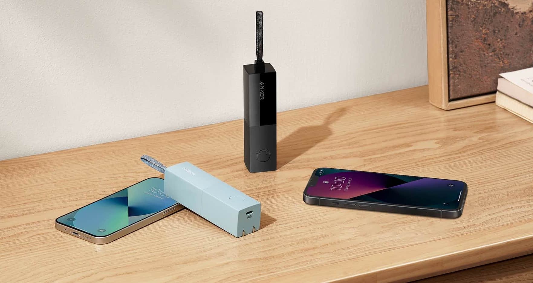 Anker 511 Power Banks in two different colors shown next to two phones lying on a table