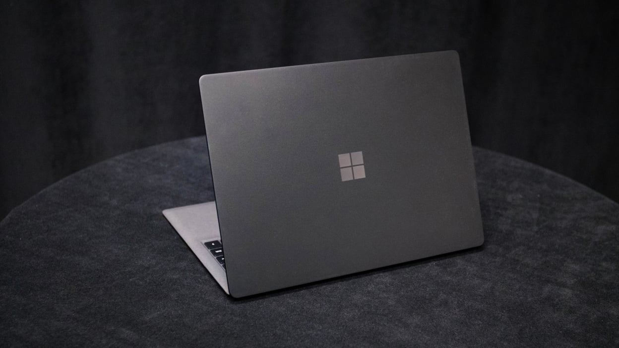 A greyish Microsoft Surface Laptop 2 on a dark, circular tabletop