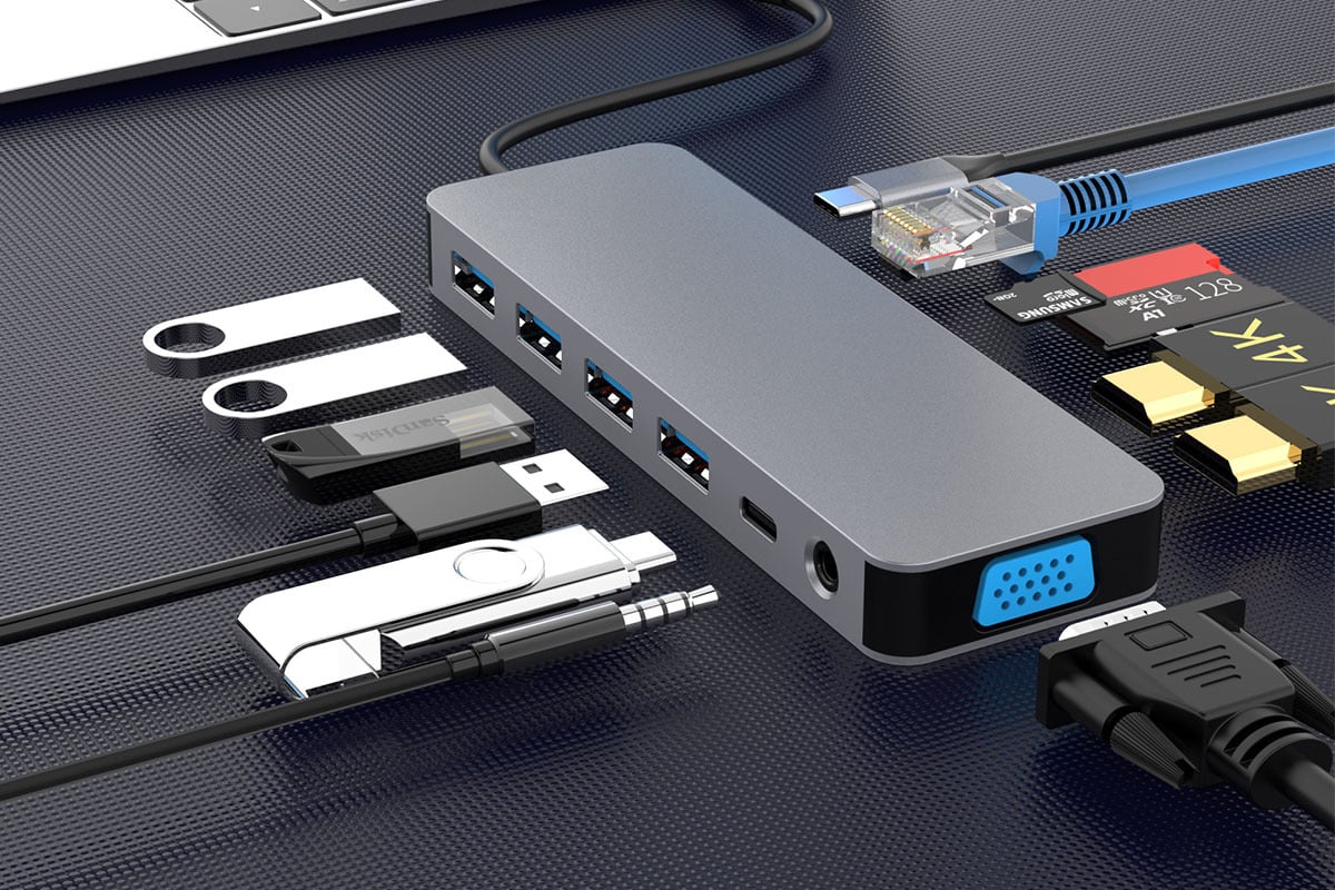 Grey docking station with a variety of cords, chargers, and plugins surrounding it 