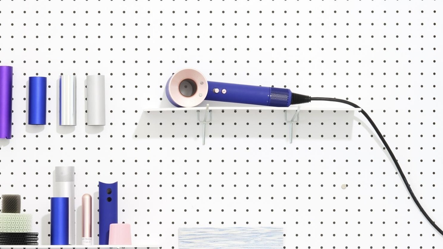 dyson supersonic on peg board among other supplies