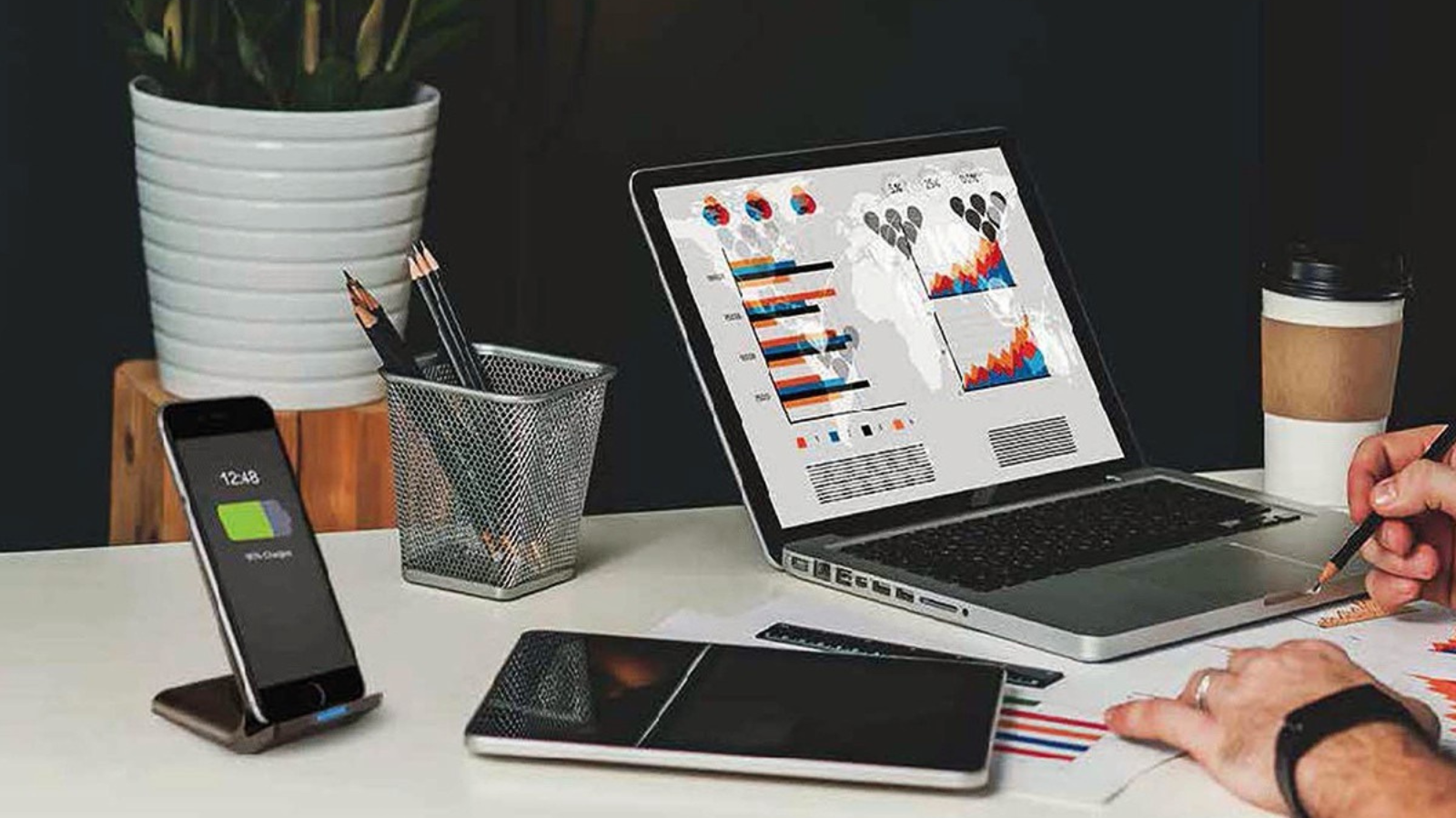 workspace with polaroid charging stand, laptop, ipad, and other accessories