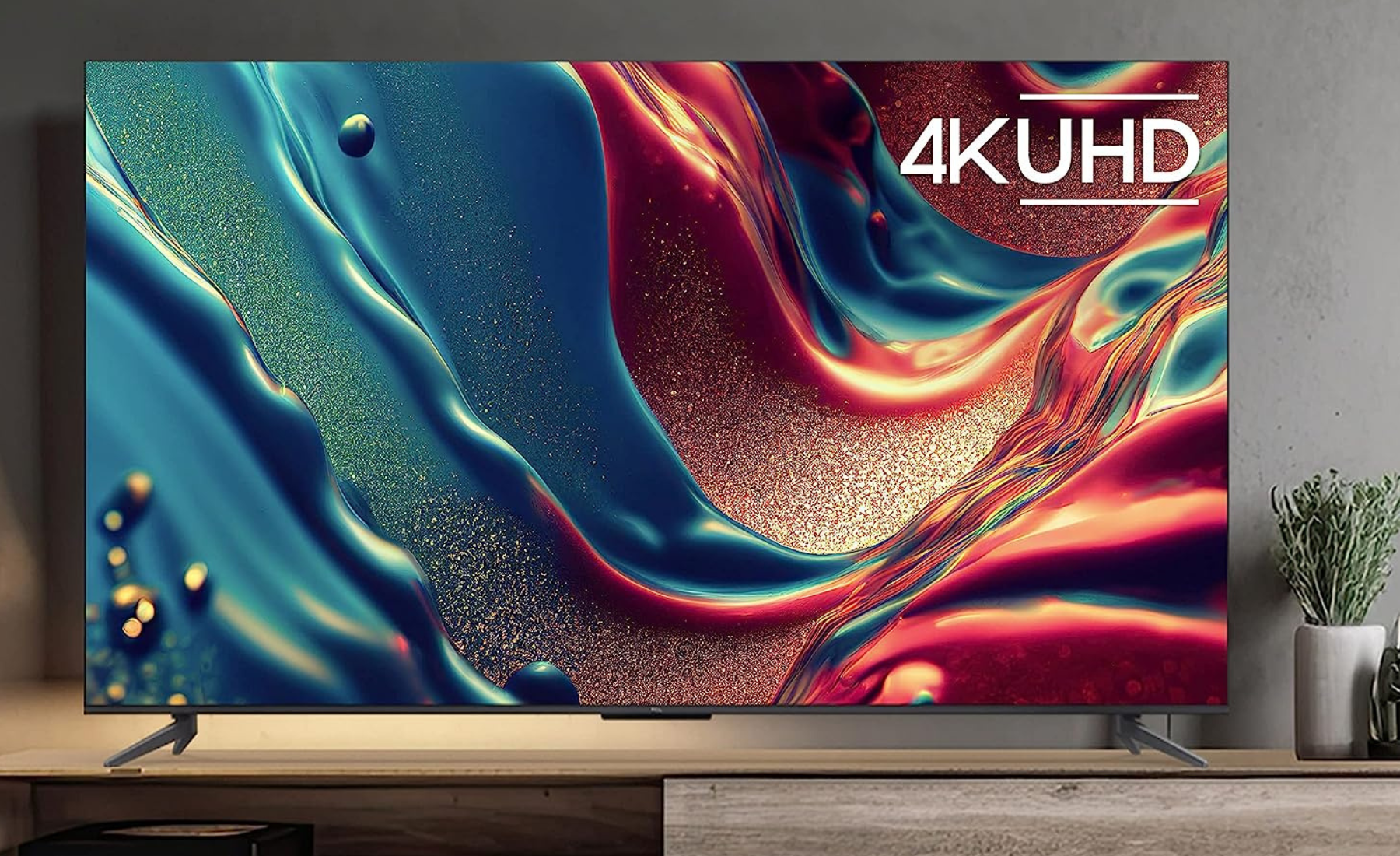 TCL TV with colorful abstract screensaver on wooden TV stand
