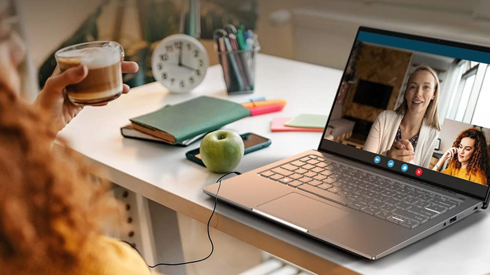 laptop on desk showing a call with one woman on the larger screen and caller on the bottom right