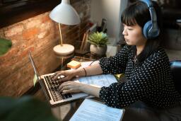 woman with headphones using a laptop