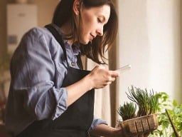 woman taking a picture of a plant