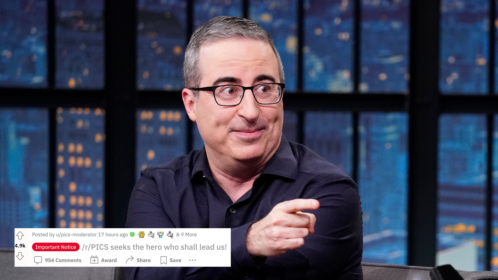 A man sitting in a talk show chair points at the host.