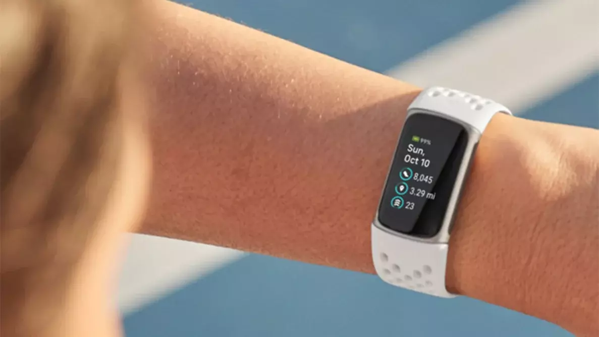 The Fitbit Charge 5 in a white color on someone's wrist