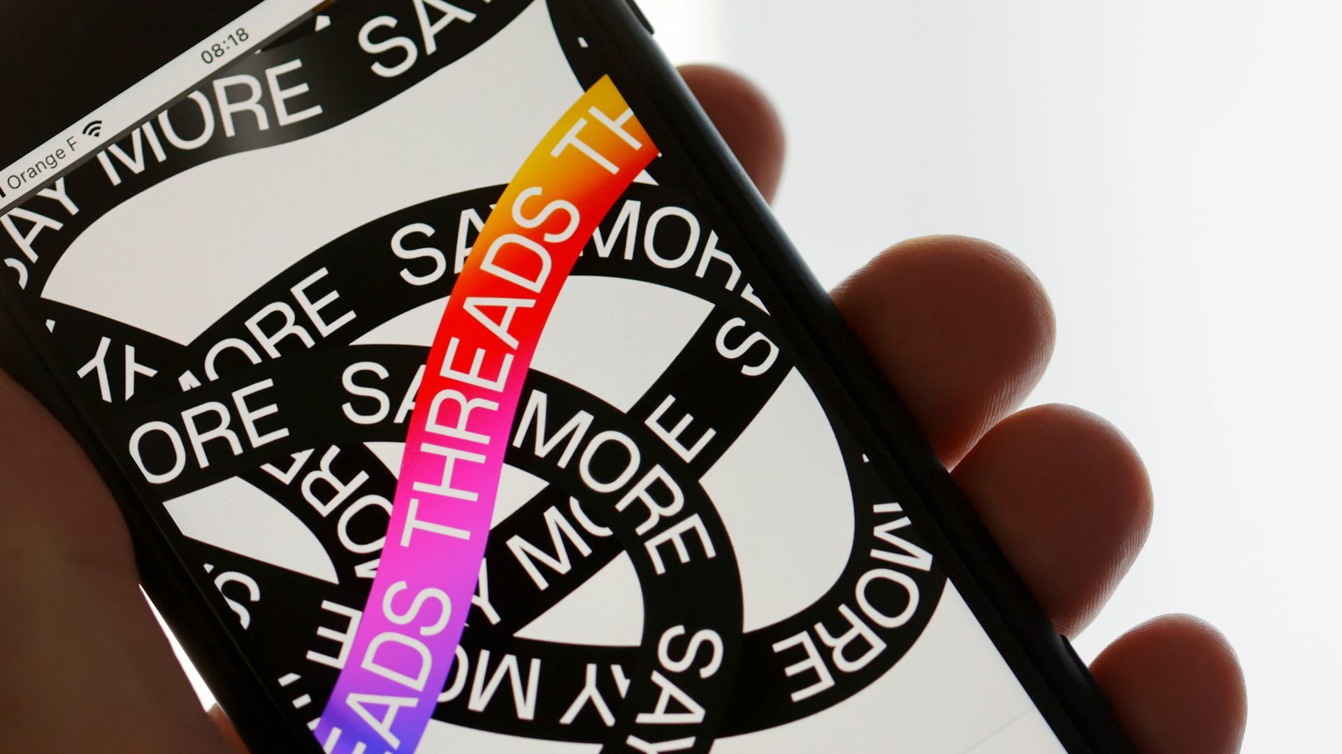 An iPhone showing the Threads home-page and logo.