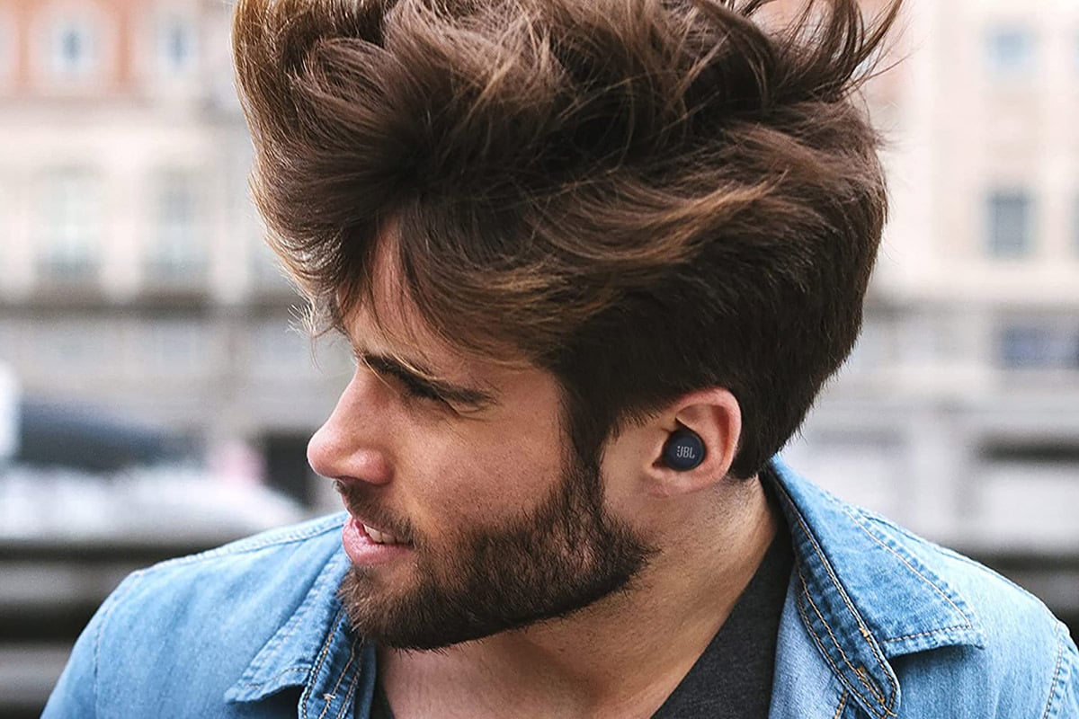 JBL Live Free NC+ earbuds in a man's ear while his head is turned to the side