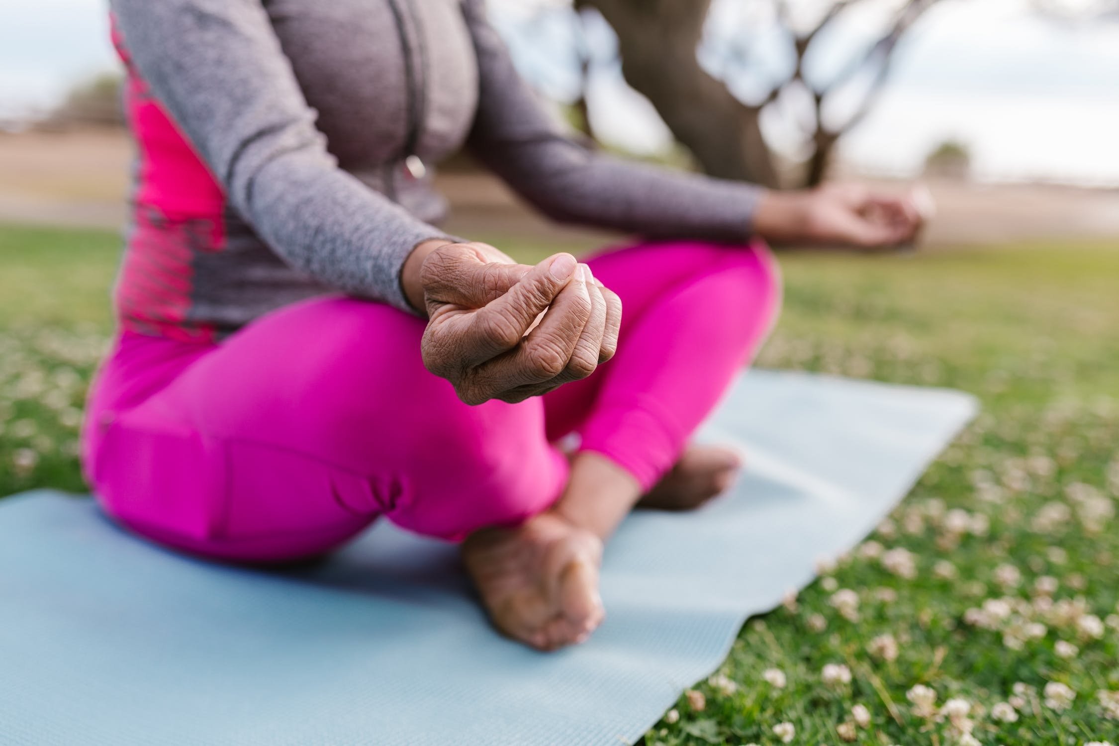 Someone sitting criss-cross-applesauce on a yoga mat.