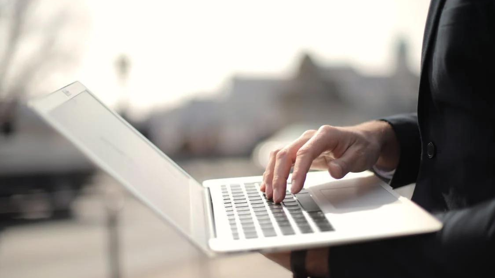 person sitting outside using macbook