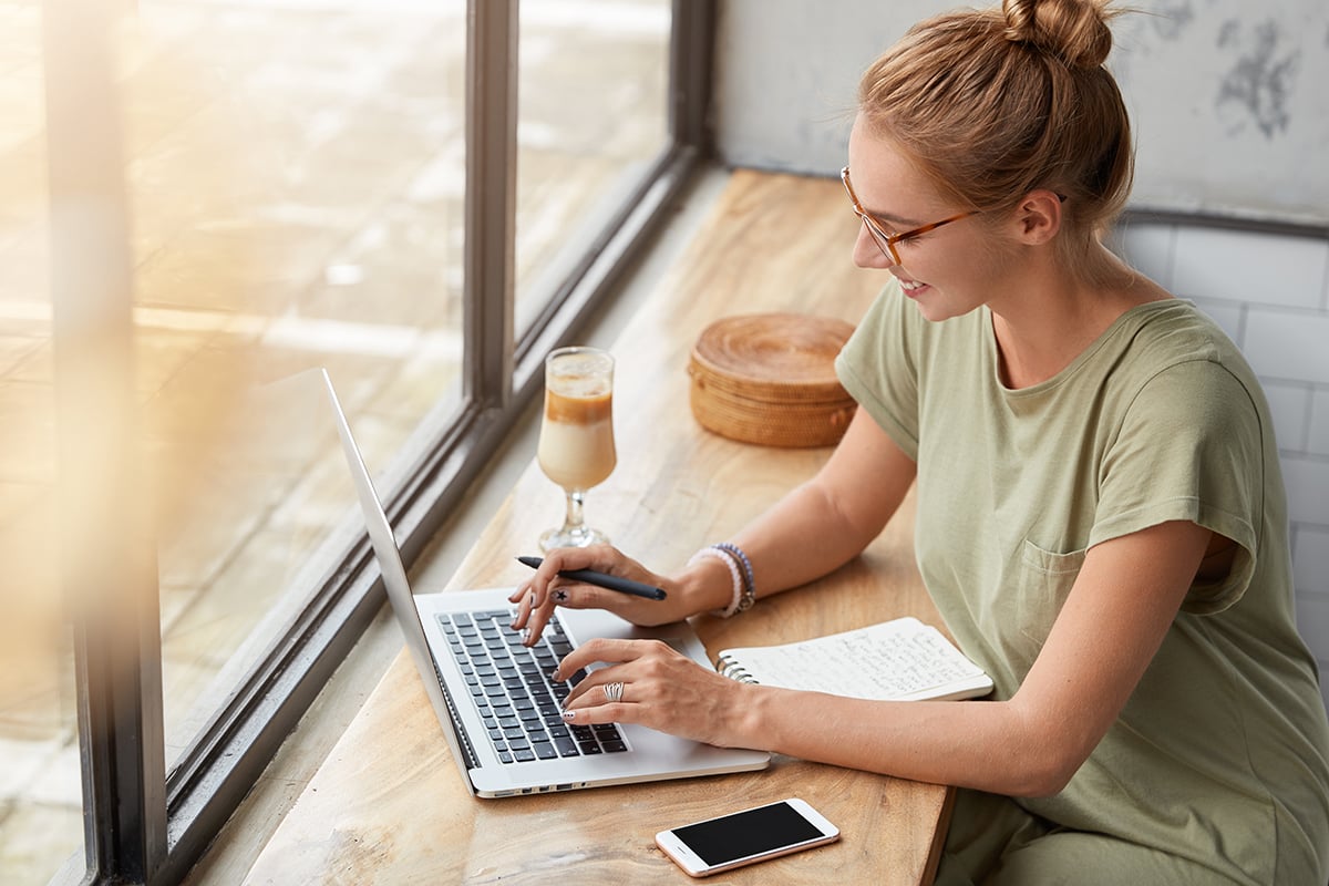 woman using a laptop at a cafe