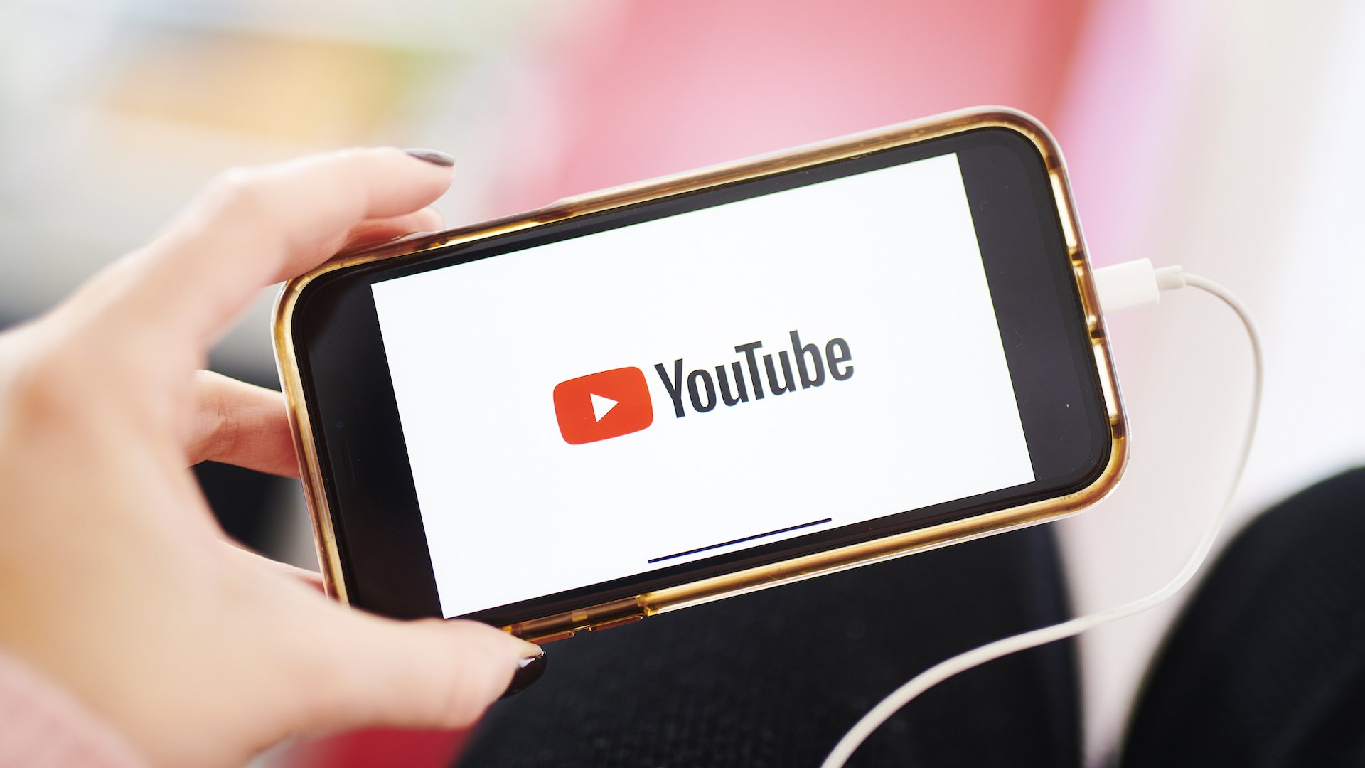 The logo for YouTube Inc. is displayed on a smartphone in an arranged photograph.