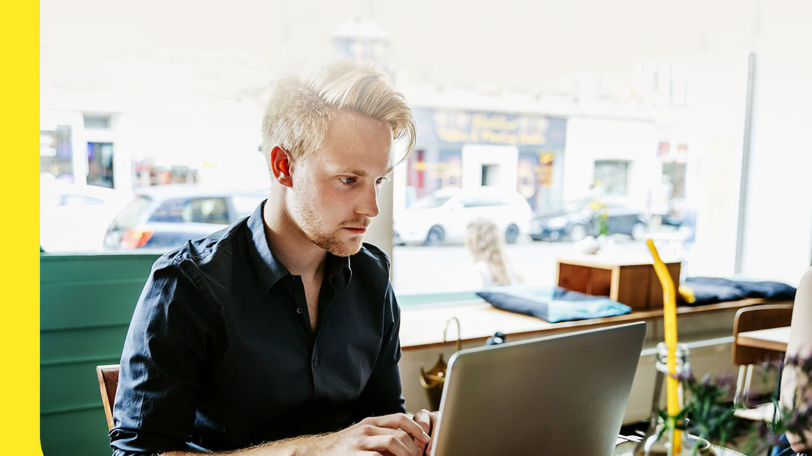 man using laptop in coffee shop