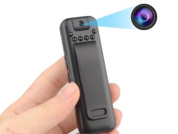 The Mini Body Camera Video Recorder in someone's hand projecting a beam