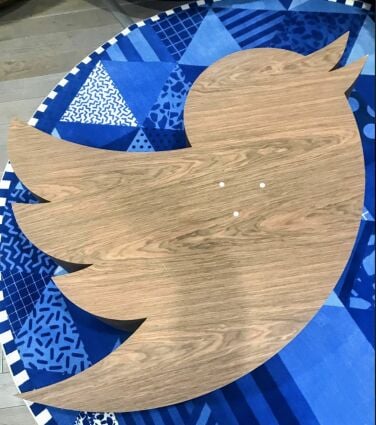 A photo of the bird table in situ on a blue patterned rug.