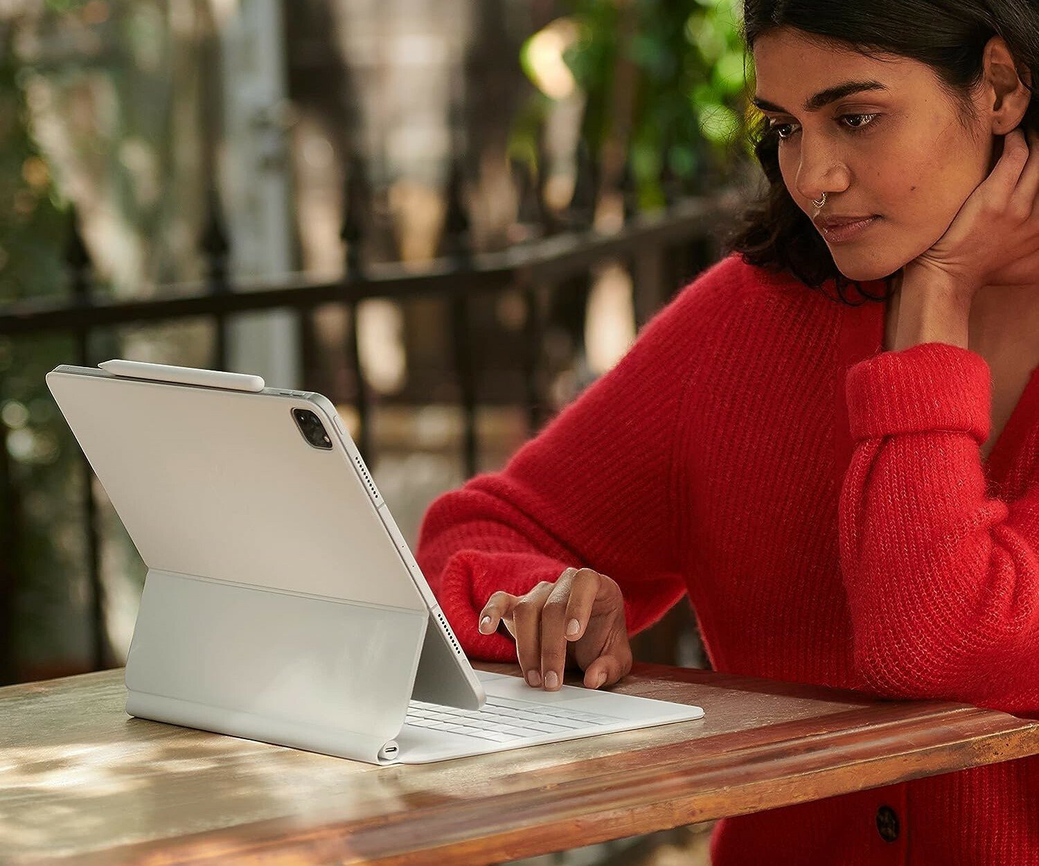 a woman looks at an iPad that's attached to an Apple Magic Keyboard