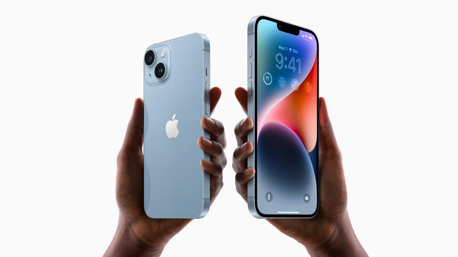 a close-up of two people's hands holding apple iphone 14s against a light gray background