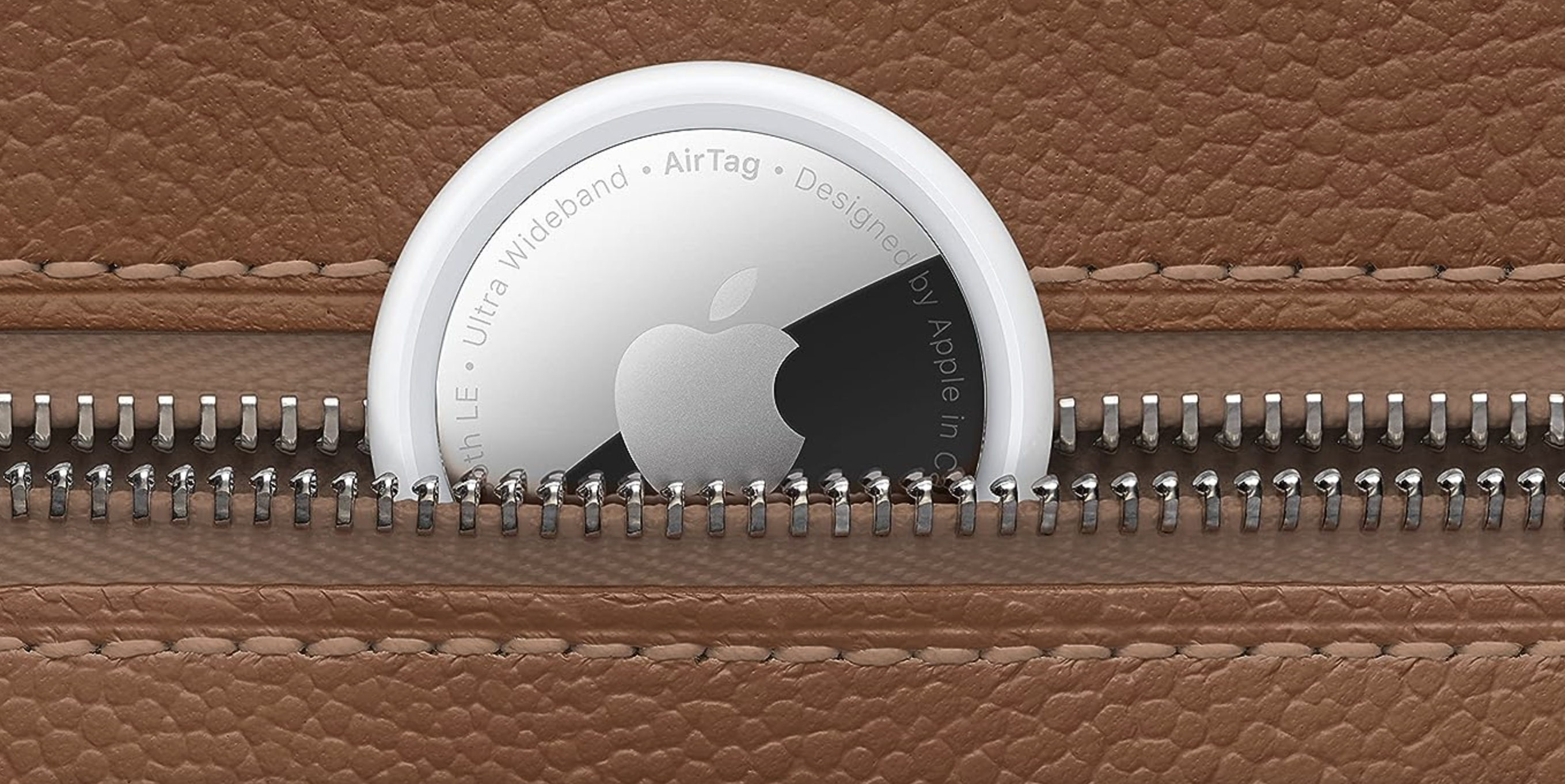 close-up of Apple AirTag tucked into leather luggage