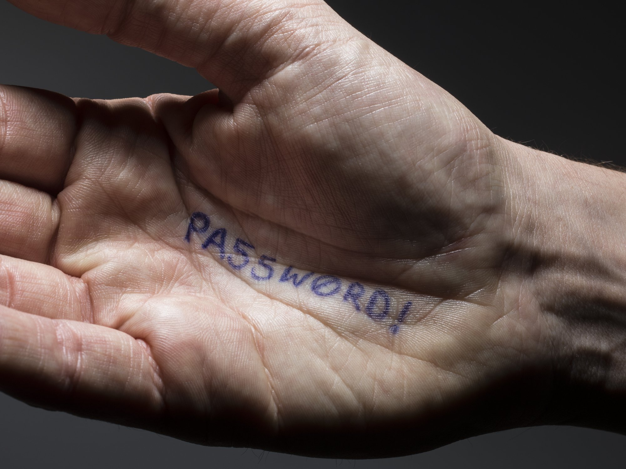 the word password written on the palm of a man's hand
