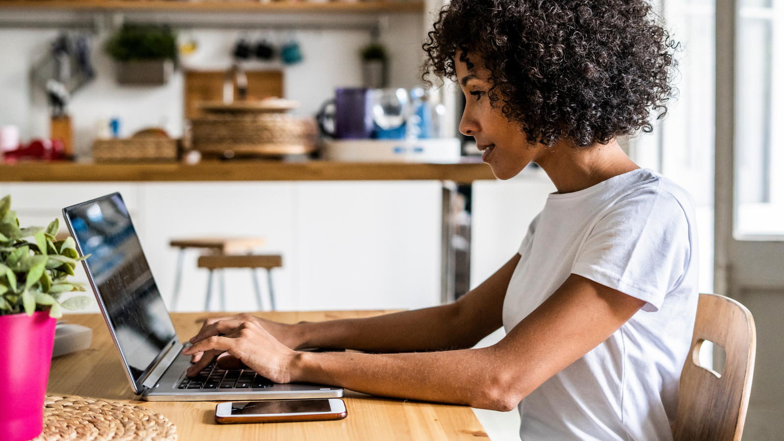 woman sitting at desk working on laptop