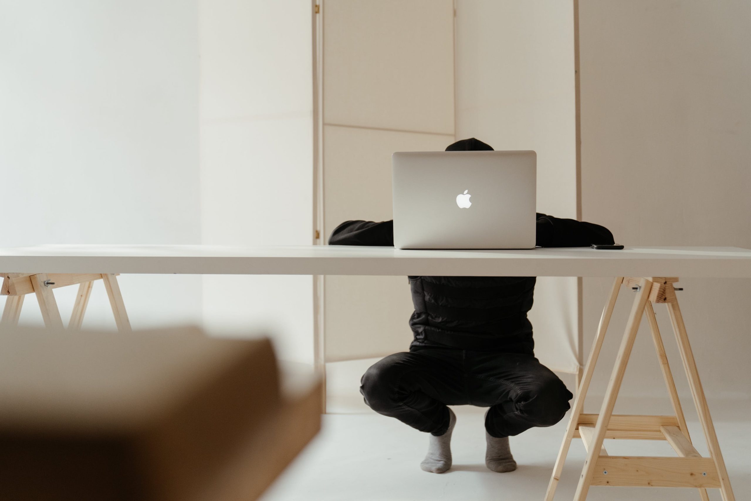 Person squatting in front of laptop