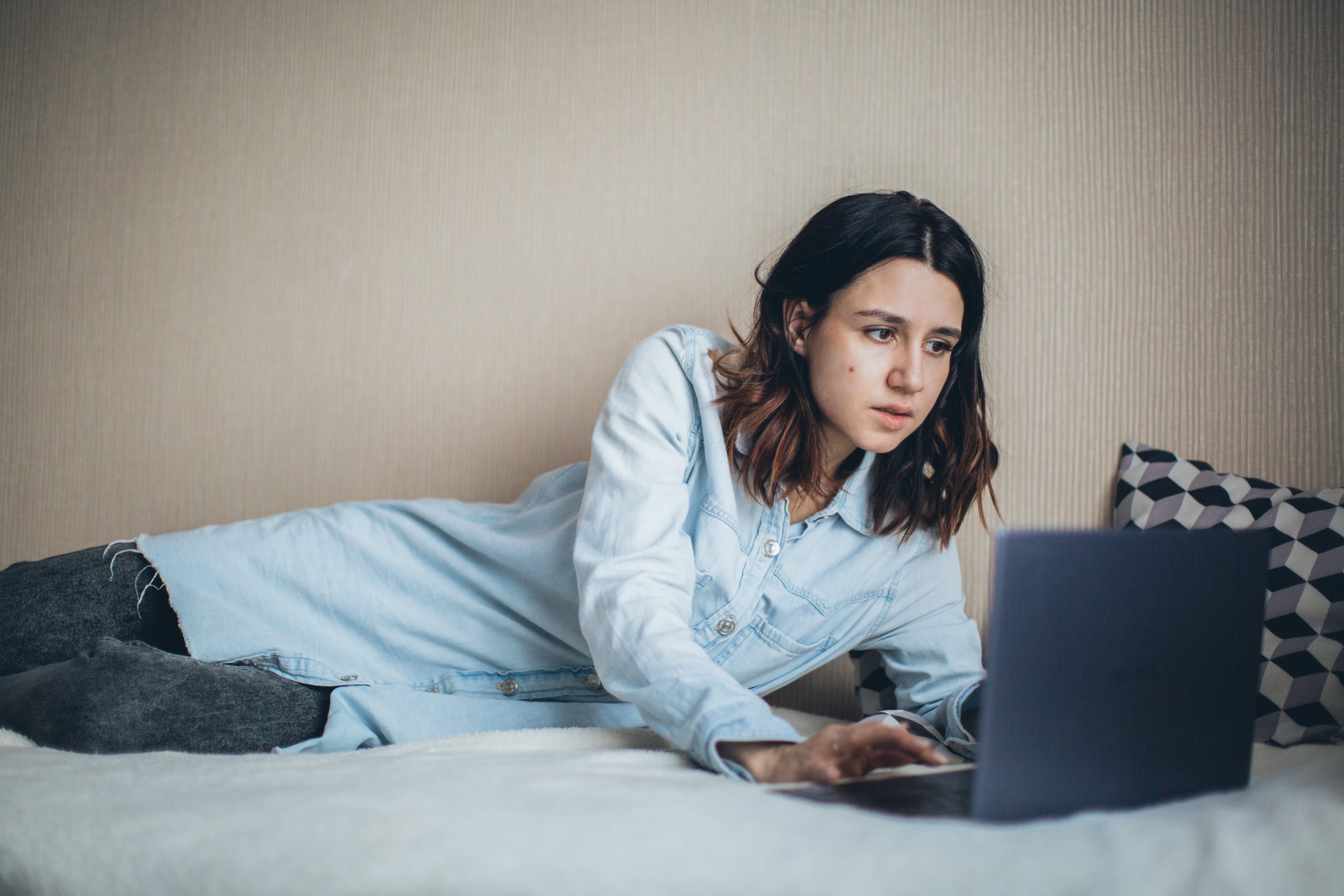Girl lying down looking at laptop