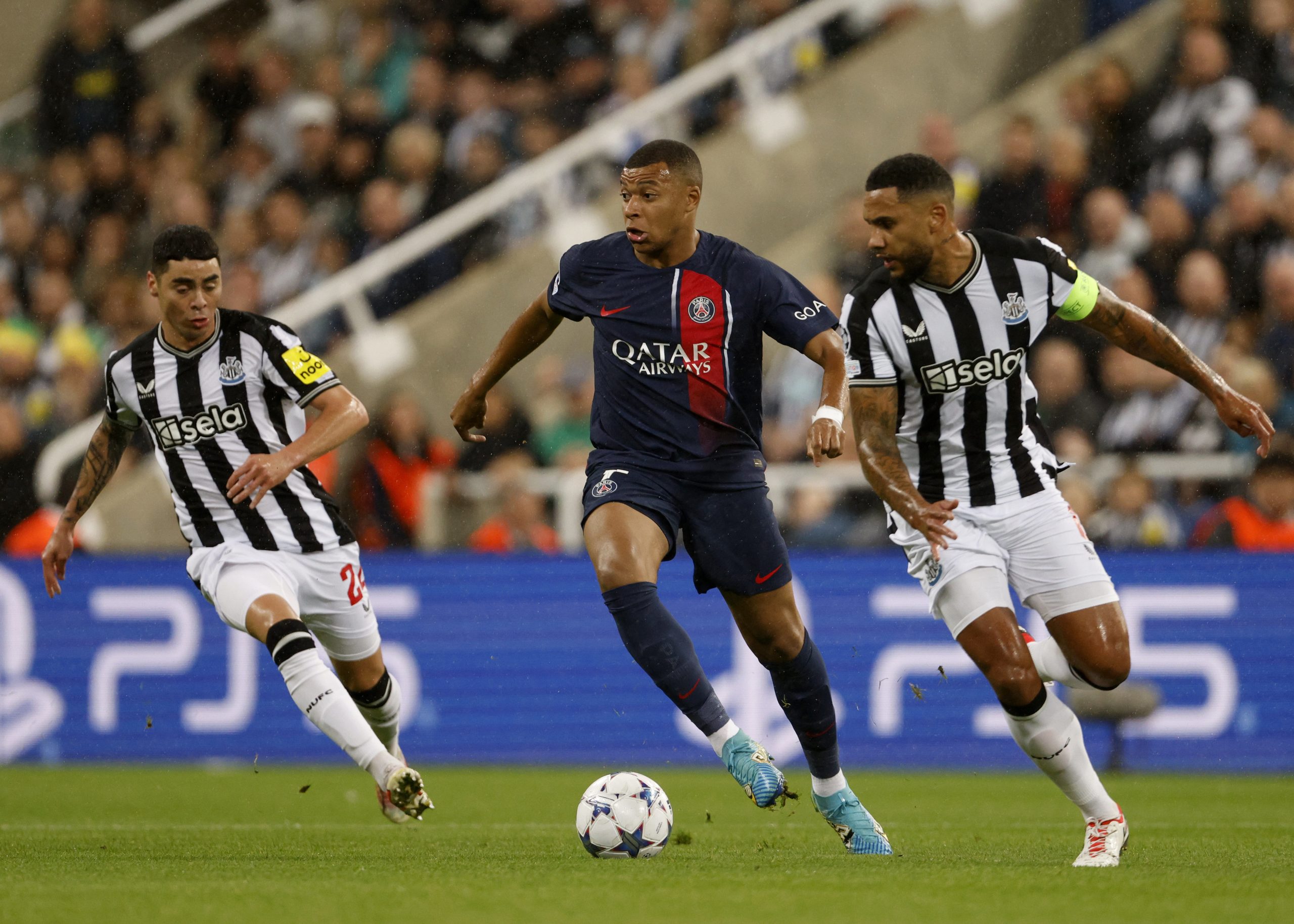 Kylian Mbappe of Paris Saint-Germain, Miguel Almiron of Newcastle United and Jamaal Lascelles of Newcastle United in action