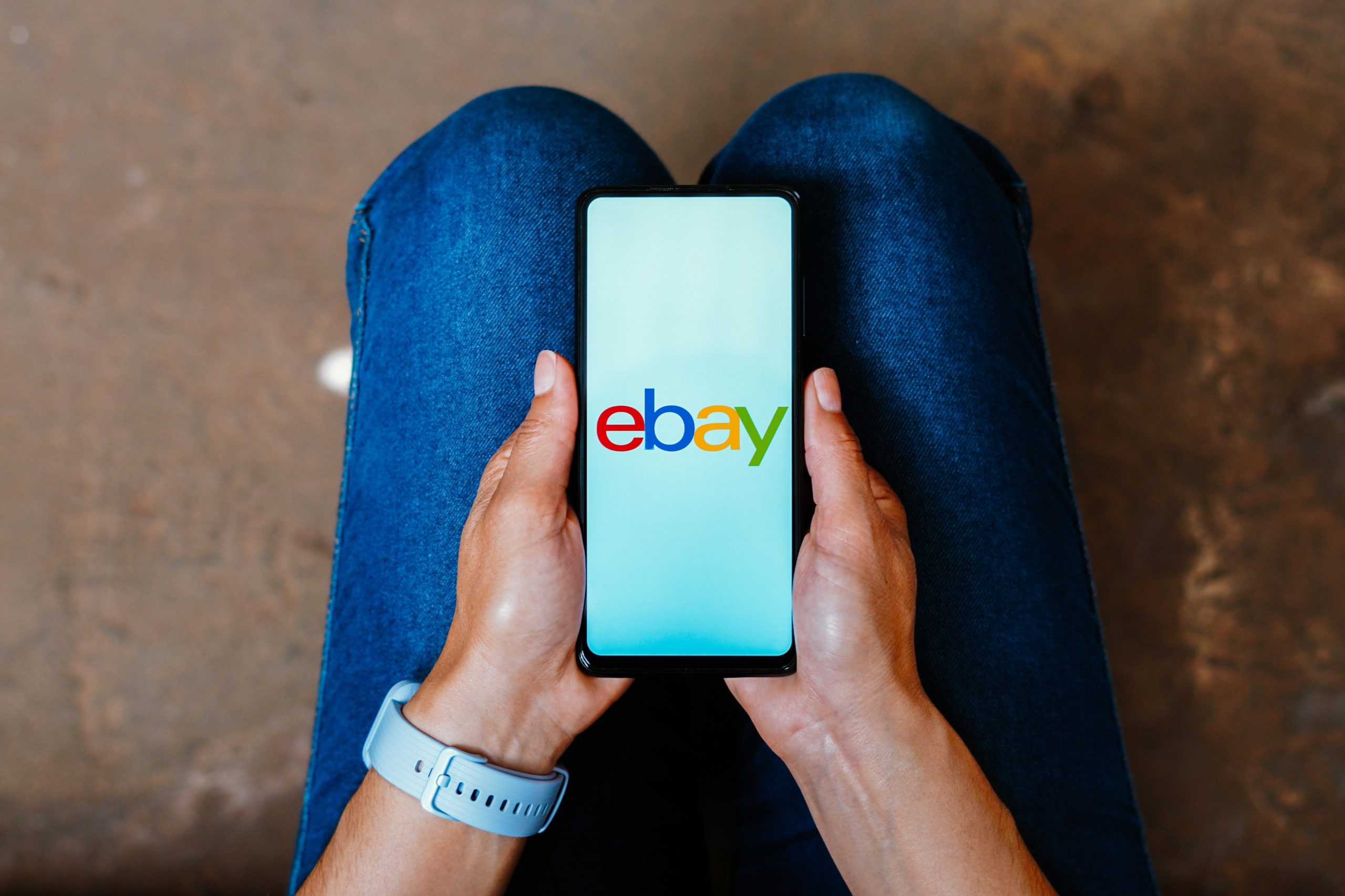 The eBay logo is displayed on a smartphone screen