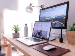 A laptop and desktop computer on a desk.