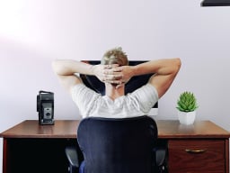 A man leaning back at desk.