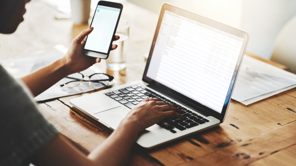 person using cloud to transfer data from phone and laptop