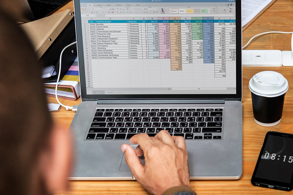 Someone typing on a computer with an open spreadsheet file