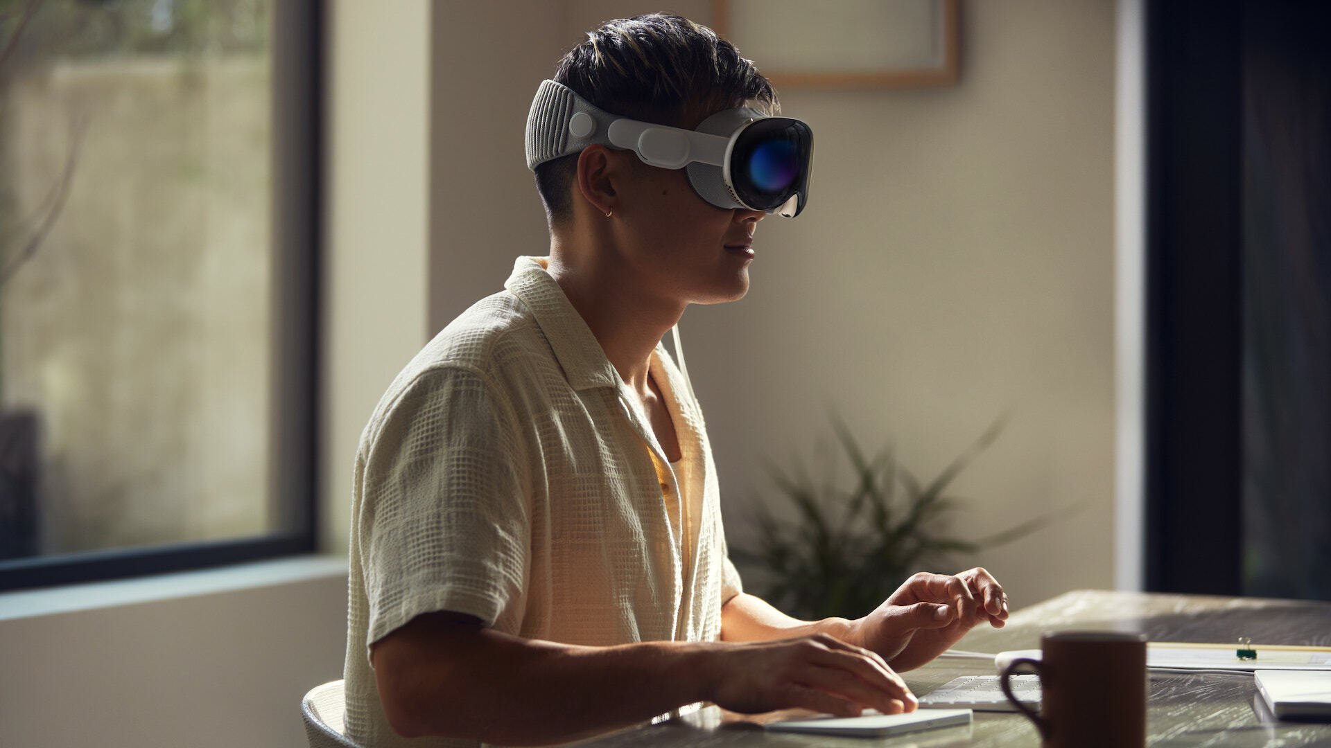 Apple Vision Pro demonstrated by a person working at their desk.