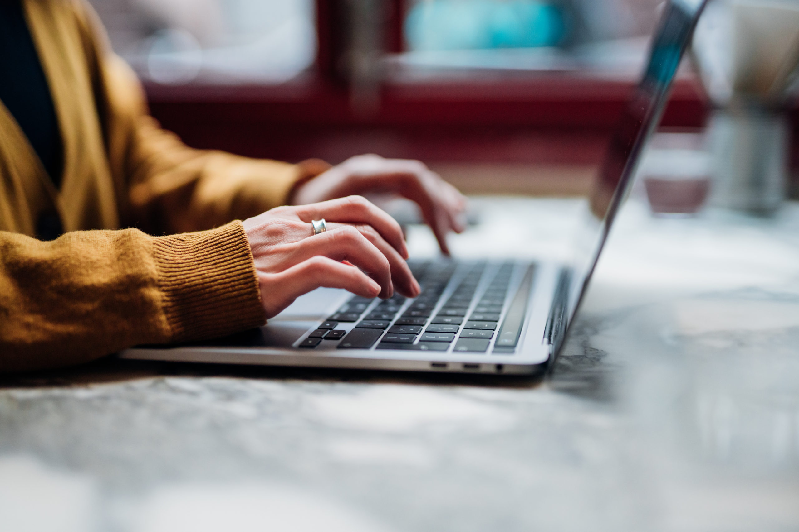 close up of woman typing on laptop