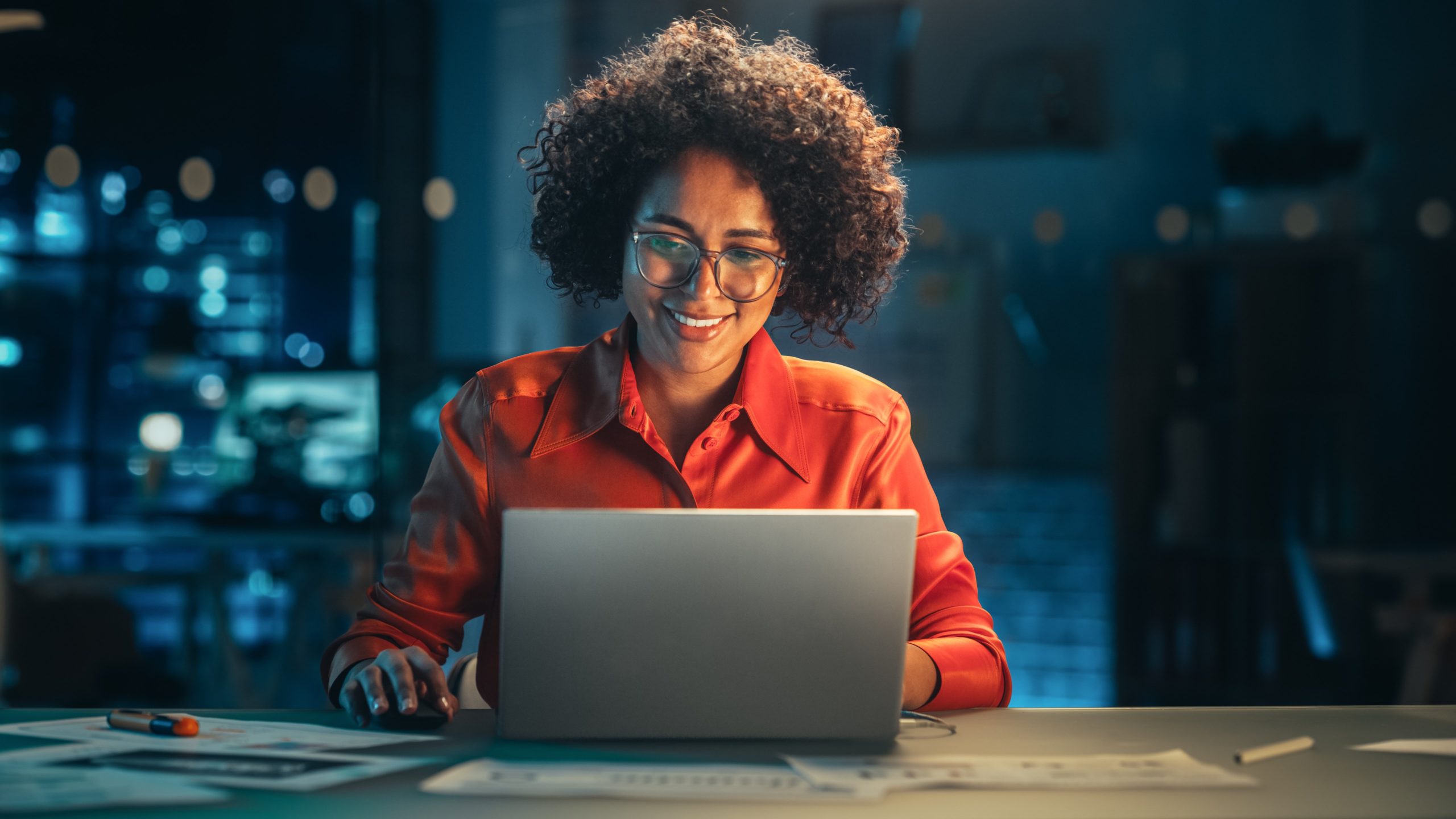 Woman smiles at laptop.