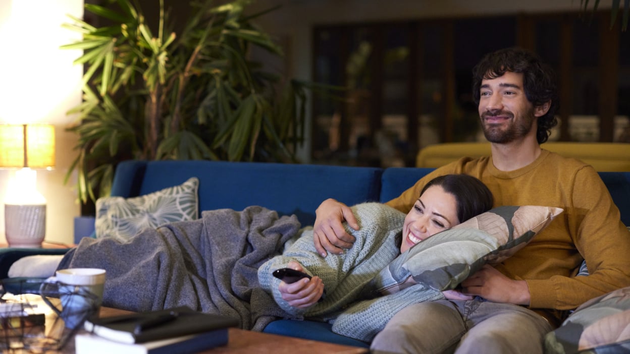 Couple on sofa with remote