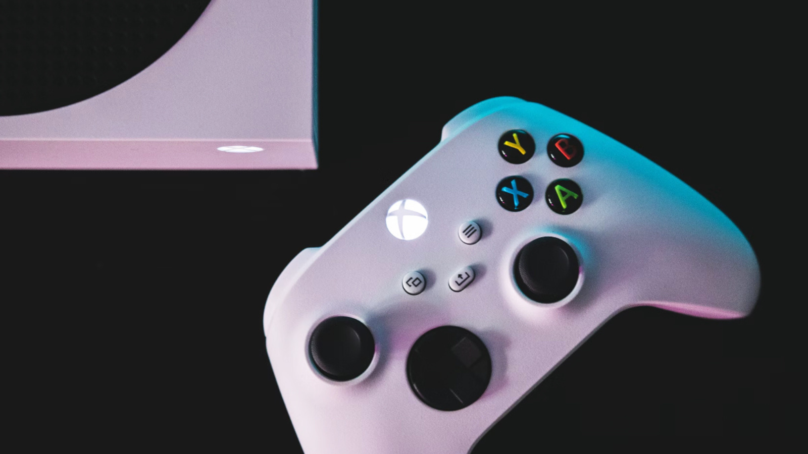 Xbox controller and console against a black backdrop