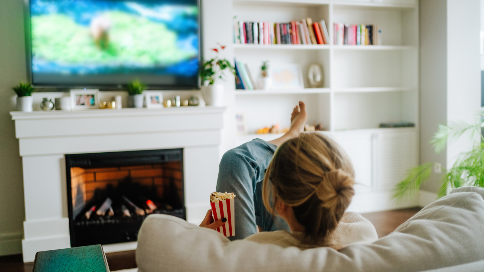 woman lounging on couch watching tv