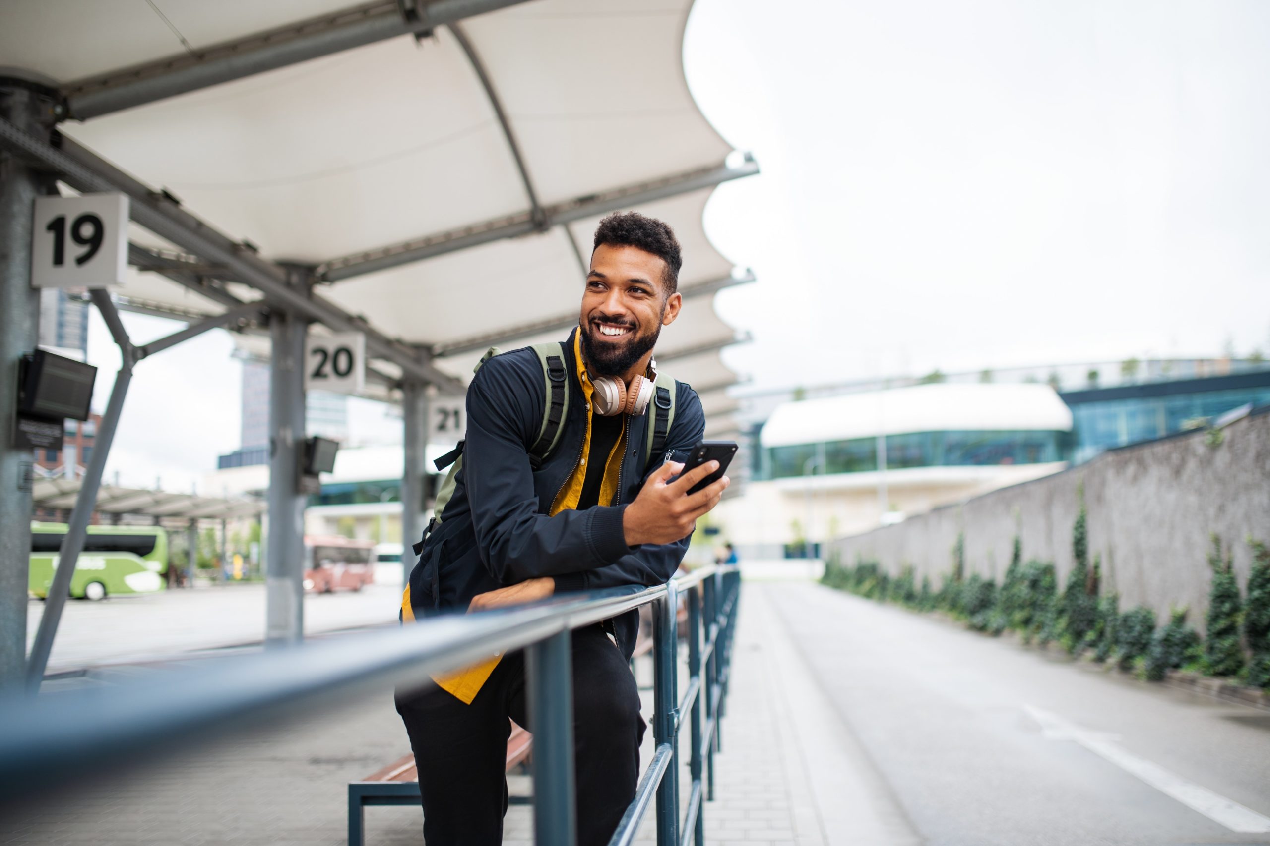 man using cellphone at a train station